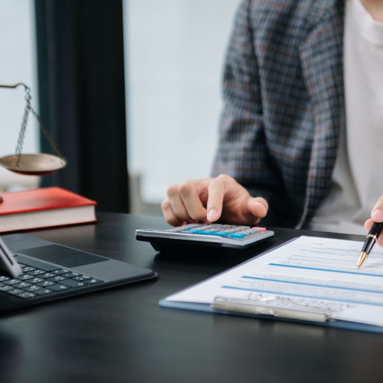Women counting coins on calculator taking from the piggy bank. hand holding pen working on calculator to calculate on desk about cost at office.